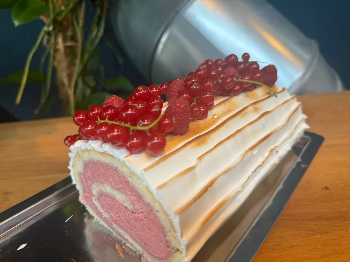 Biskuitrolle mit Himbeercreme, flambiertem Baiser und frischen Beeren